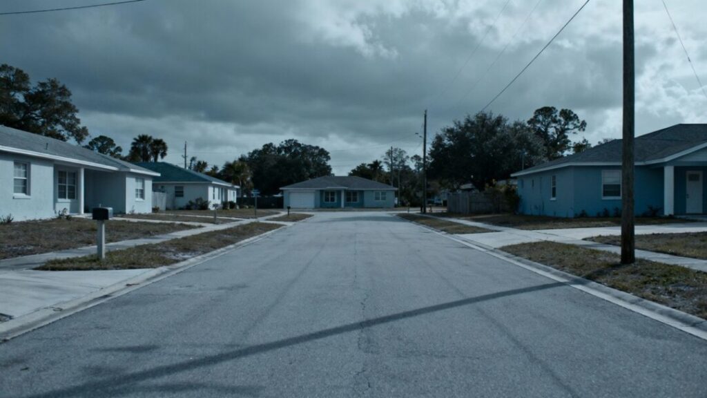 Empty Tampa street with houses under overcast sky.