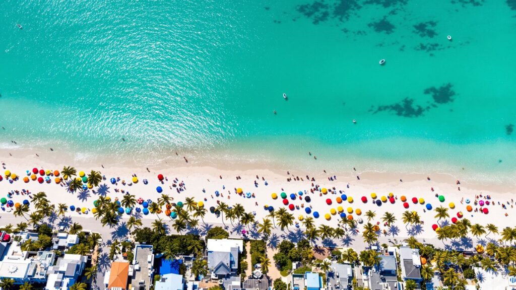 Sunny Florida beach town with turquoise water and white sand.