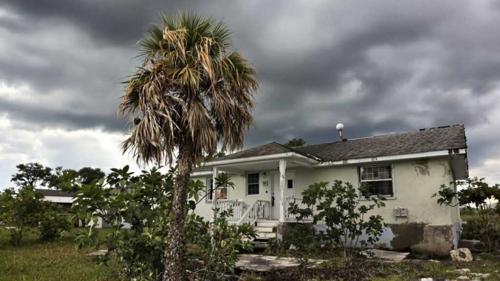Florida vacation rental property in disrepair under stormy sky.