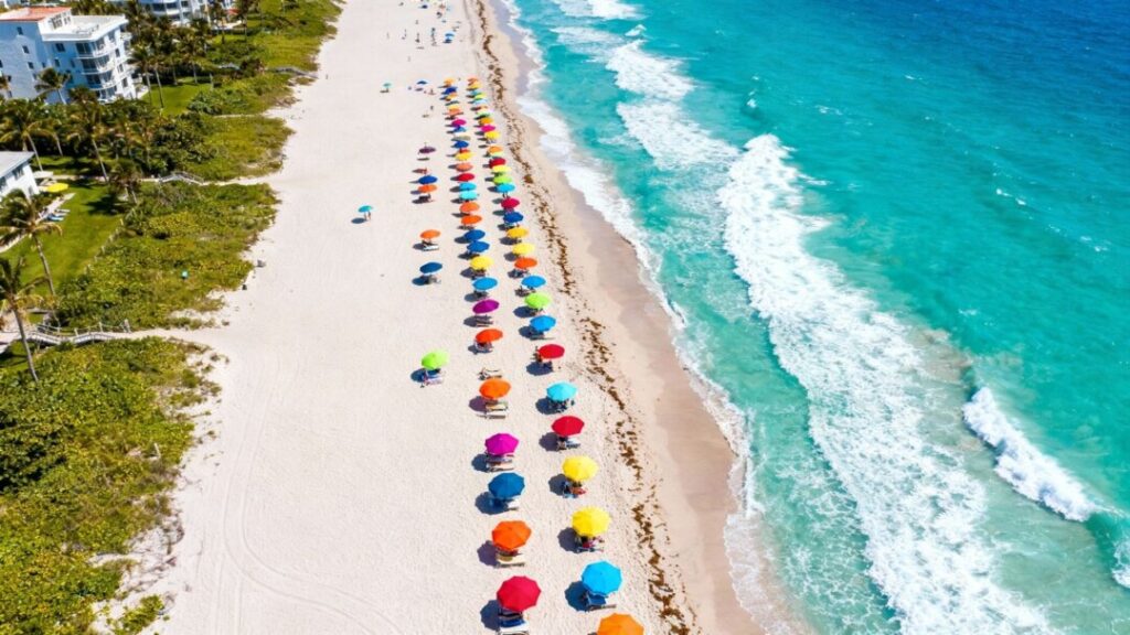 Delray Beach coastline with umbrellas and ocean waves.