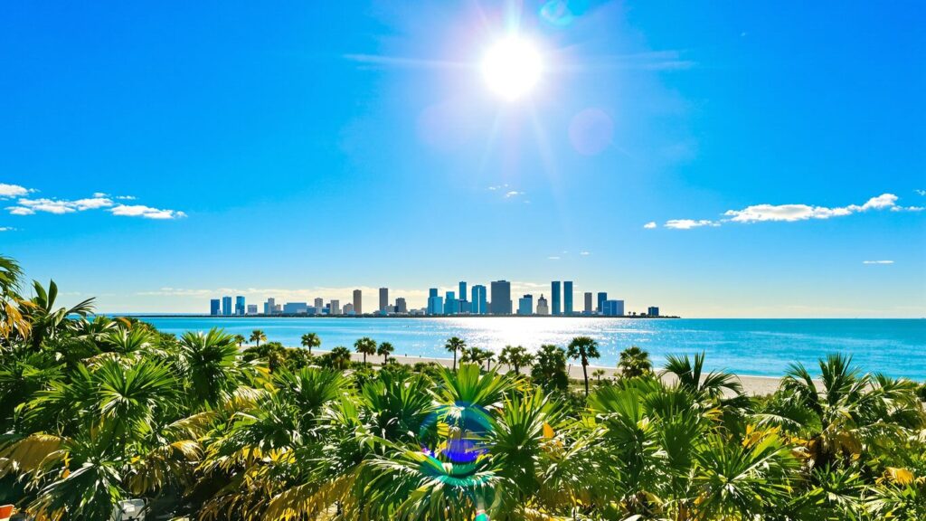 Florida coastline and city skyline under a sunny sky.