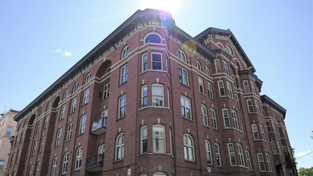 Historic brick apartment building with arched windows.
