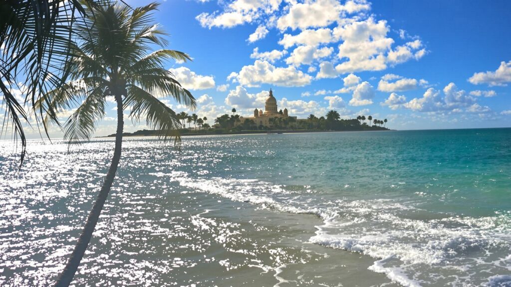 Florida coastline and capitol building under a sunny sky.