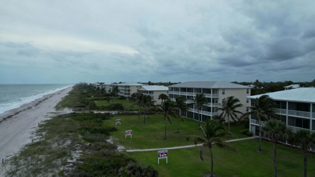 Florida condos with for sale signs on empty beach