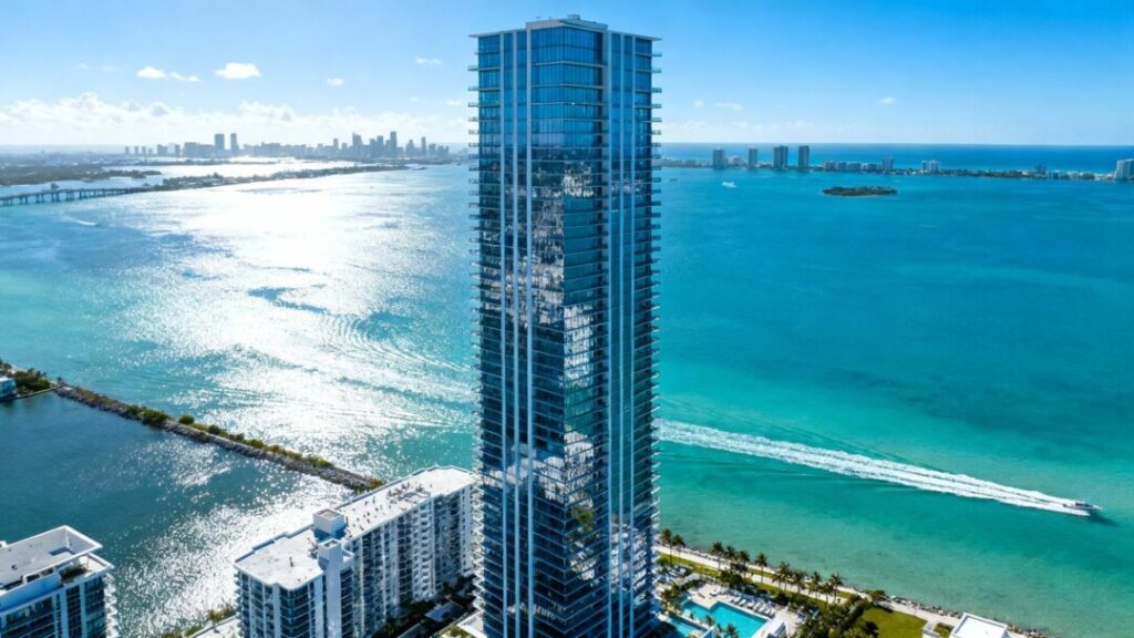 Miami luxury condo tower against a blue sky.