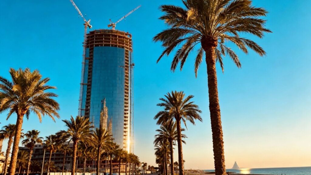 South Florida skyscraper construction with palm trees and ocean view.