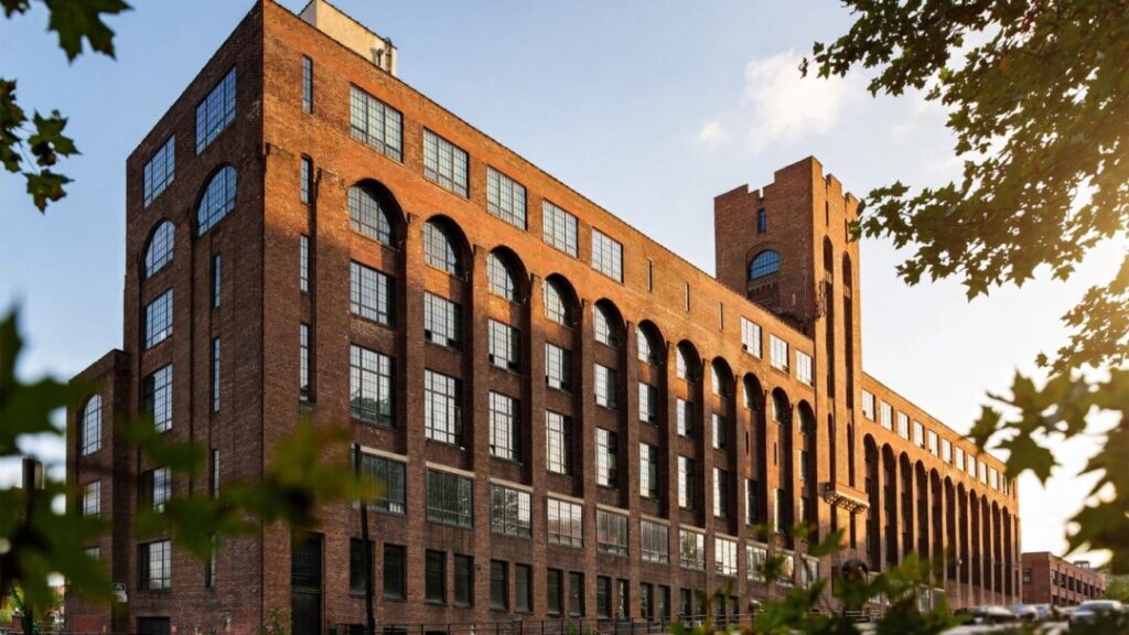 Historic red-brick BankNote Building beneath a clear Bronx sky