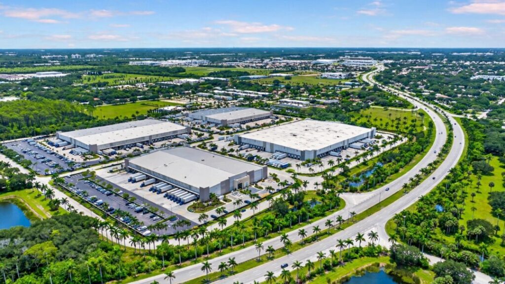 Florida industrial warehouses beside a sunlit highway and palm trees
